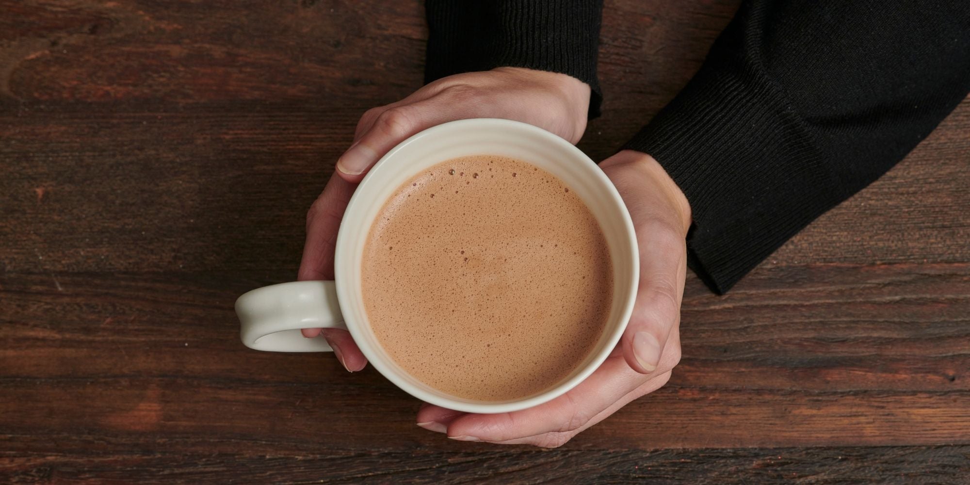 Hands holding hot chocolate in a mug